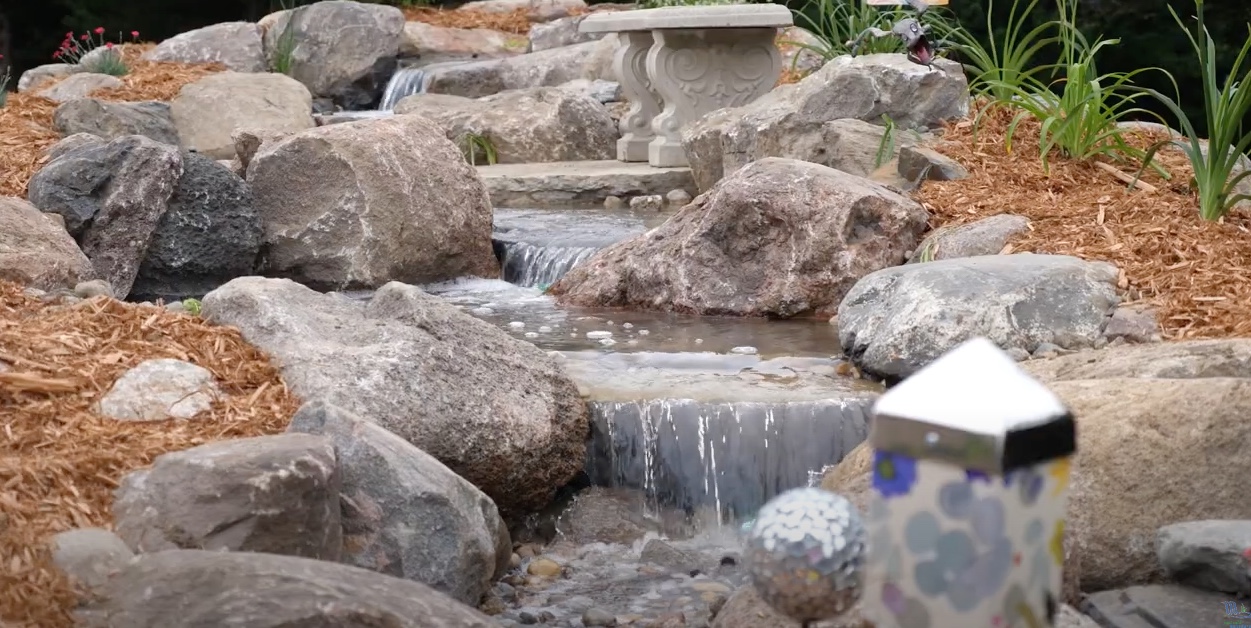 Small waterfall in landscaped garden with rocks